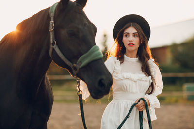 Portrait of young woman holding horse