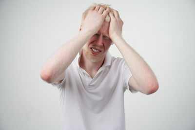 Portrait of man wearing hat standing against white background