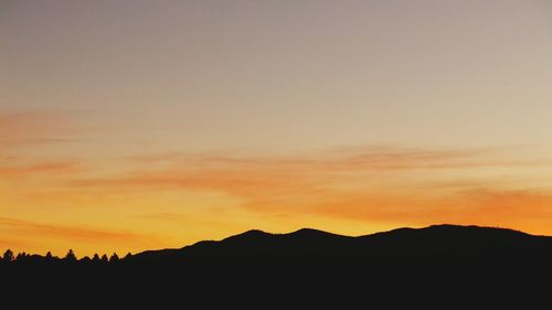 Scenic view of silhouette mountains against dramatic sky