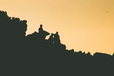Silhouette people against clear sky during sunset