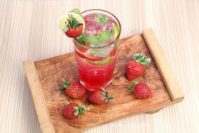 High angle view of drink by strawberries on table