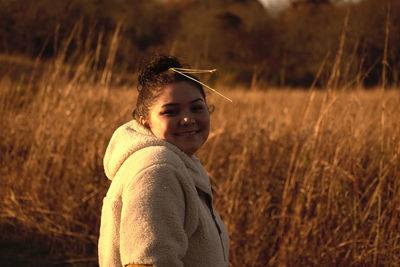 Portrait of teenage girl standing on field