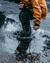 Low section of man standing in water