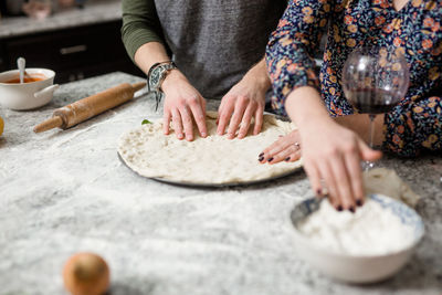 Midsection of women preparing food in kitchen