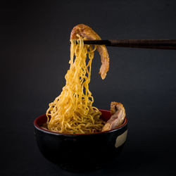 Close-up of pasta in bowl against black background