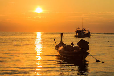 Silhouette boat in sea against sky during sunset