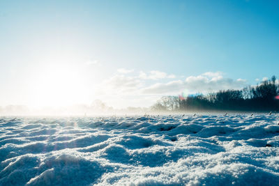 Scenic view of snow covered field against sky