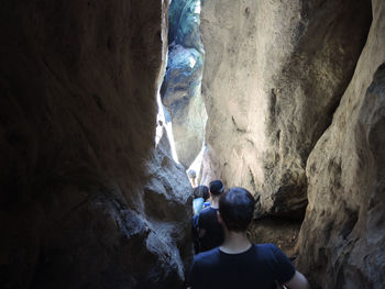 Rear view of woman standing on rock formation