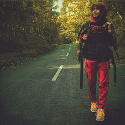 Portrait of young woman standing on road