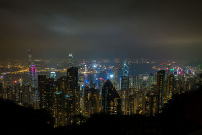 Illuminated cityscape against sky at night