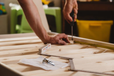 Cropped hands of man working on wood at home