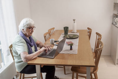 Senior woman using laptop at table