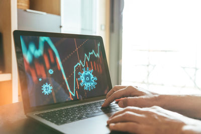 Midsection of man using laptop on table