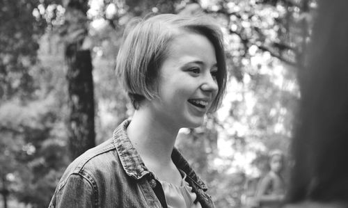 Portrait of smiling young woman looking away outdoors