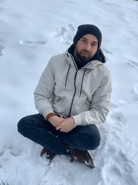 Young man sitting in snow