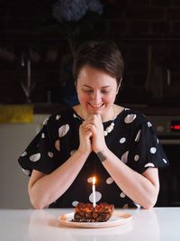 Portrait of woman blowing birthday cake