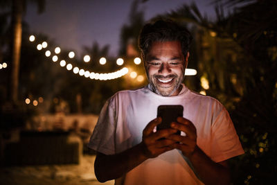 Happy man texting during sunset