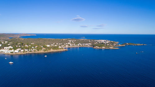 Aerial view of sea and town against blue sky