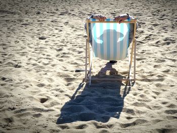 Person relaxing in deck chair at beach