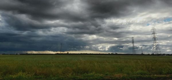 Scenic view of field against cloudy sky