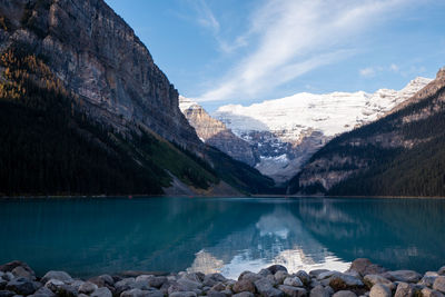 Scenic view of lake by mountains against sky