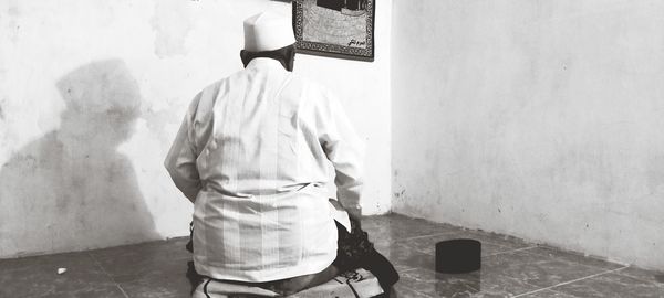 Rear view of man standing against wall