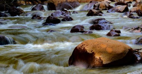 View of stream flowing through rocks