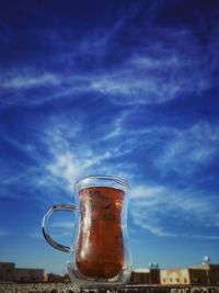 Glass of beer against blue sky