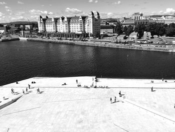 People walking at oslo opera house against city skyline