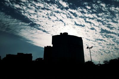 Low angle view of silhouette buildings against sky at sunset