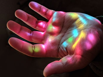 Close-up of hand over pink background
