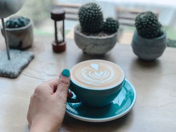 Close-up of hand holding coffee cup