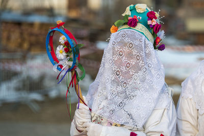 Rear view of woman with umbrella against blurred background