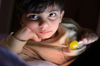 Portrait of cute boy holding lollipop