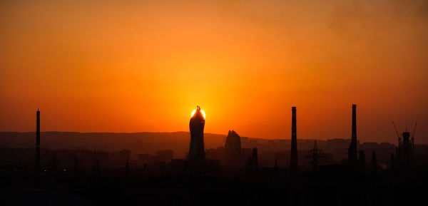 Silhouette temple against orange sky during sunrise