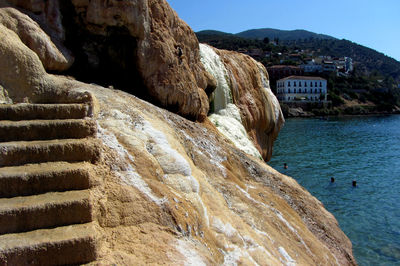 Rock formations by sea against sky