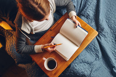 Student learning at home. young woman making notes, reading and learning from notepad