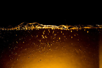 Close-up of wet glass against black background