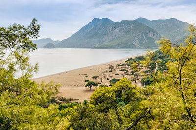 Scenic view of sea and mountains against sky