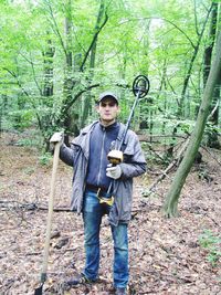 Portrait of young man standing in forest