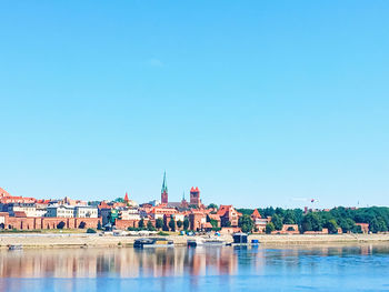 Buildings at waterfront against blue sky