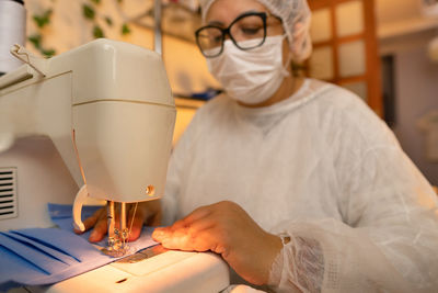 Woman wearing mask working at factory