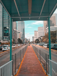 Bridge amidst buildings in city against sky