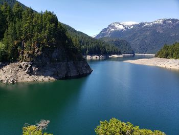 Scenic view of lake and mountains against blue sky