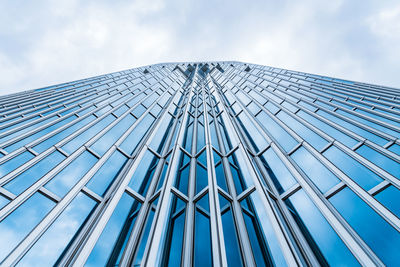 Low angle view of modern glass building against sky