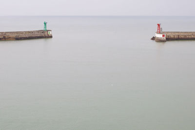 Lighthouse on sea against sky