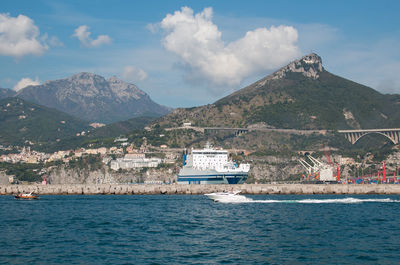 Scenic view of sea by buildings against sky