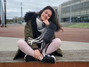 Portrait of smiling young woman sitting outdoors