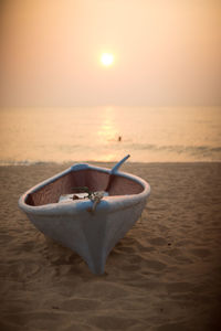 Close-up of sunglasses on beach against sky during sunset