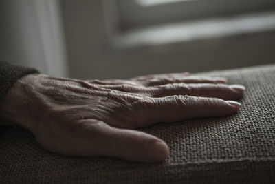 Close-up of person hand on armrest